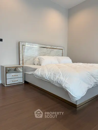 Luxurious bedroom with elegant marble headboard and sleek wooden flooring