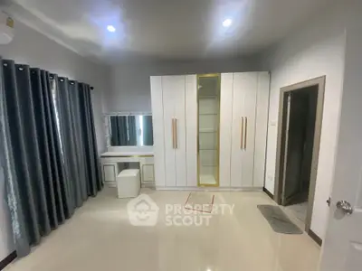 Spacious bedroom with modern wardrobe and vanity in a stylish home