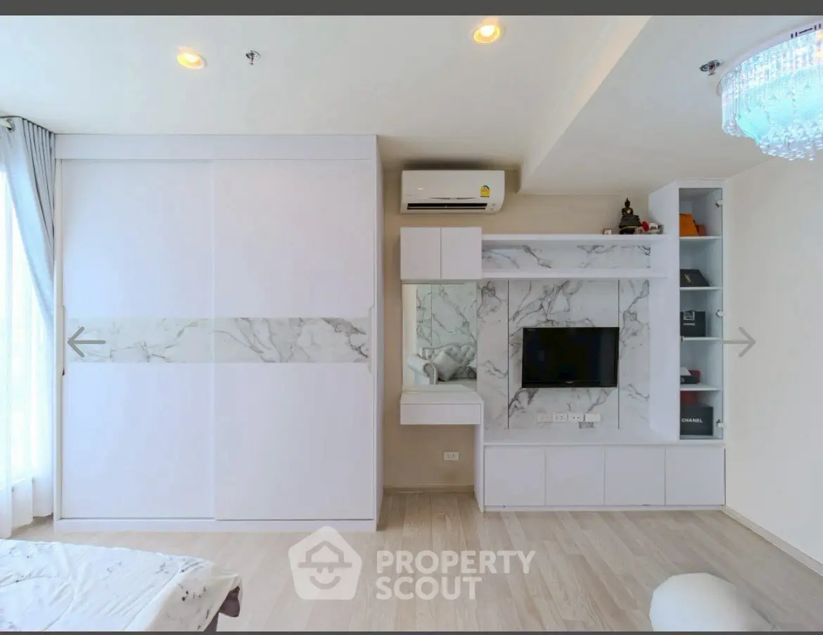 Modern living room with sleek built-in storage and TV unit, featuring elegant marble accents and ambient lighting.
