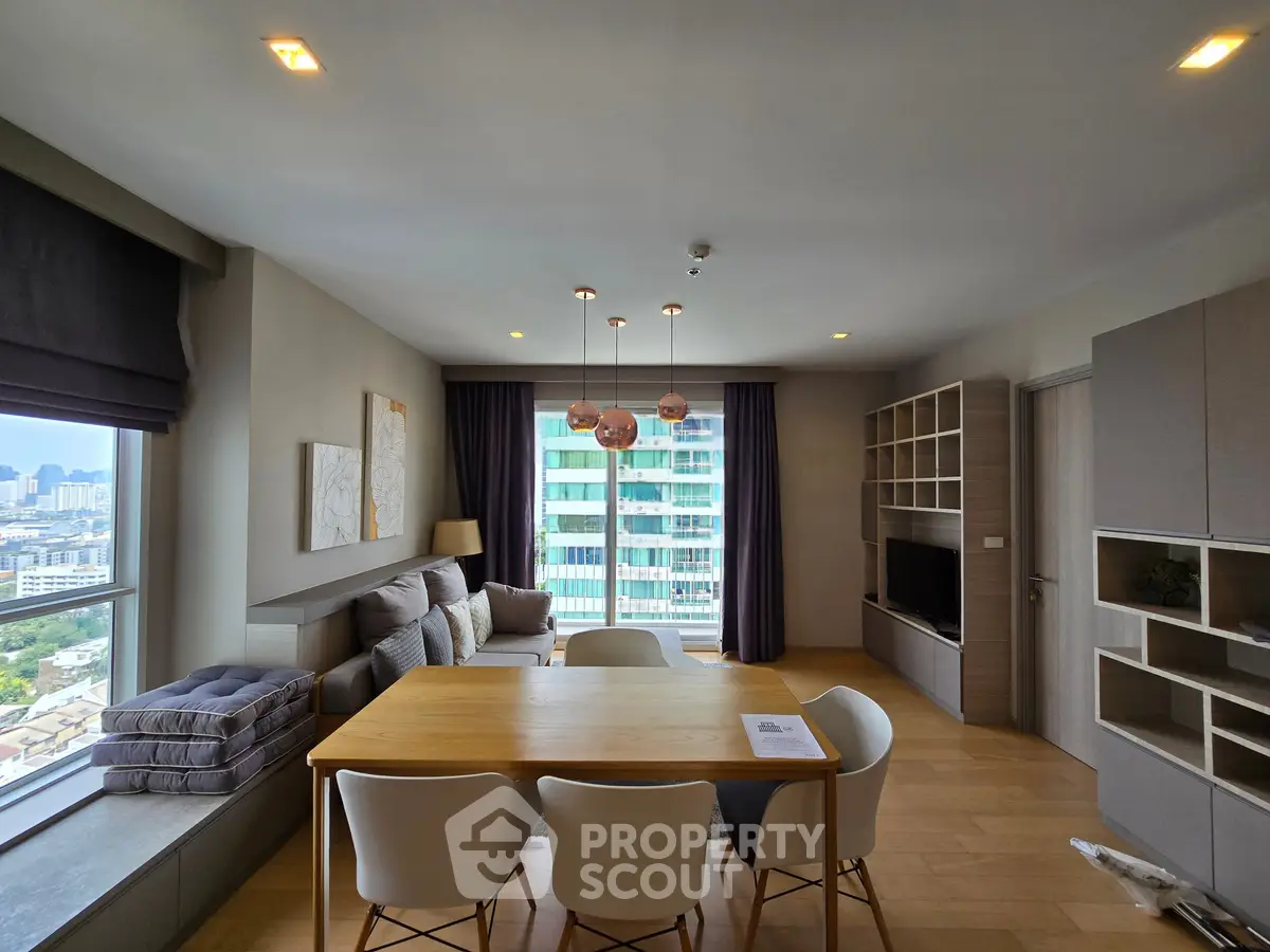 Modern living room with dining area and city view, featuring stylish furniture and large windows.