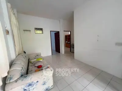 Spacious living room with floral sofa and tiled flooring in a cozy home.