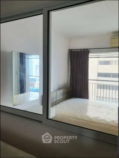 Modern bedroom with large window and balcony view, featuring a comfortable bed and stylish decor.