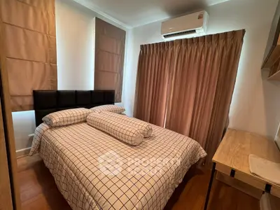 Cozy bedroom with stylish decor and ample natural light, featuring a comfortable bed and modern air conditioning.