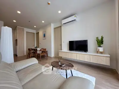 Modern living room with sleek furniture and wall-mounted TV, perfect for relaxation.