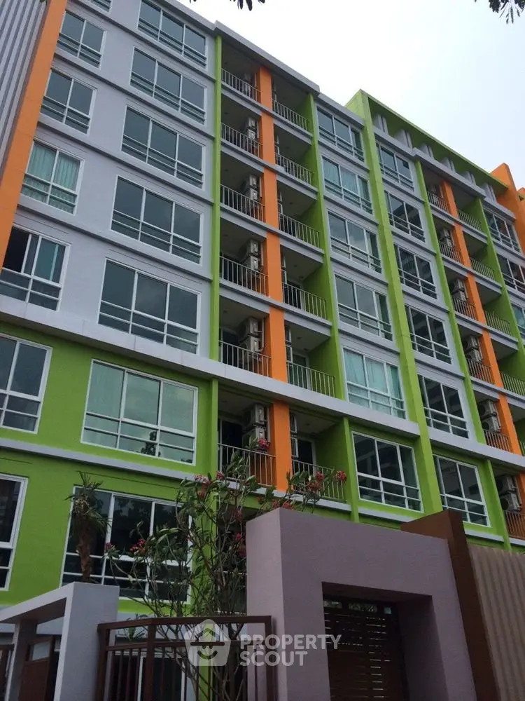 Modern colorful apartment building exterior with vibrant green and orange accents.