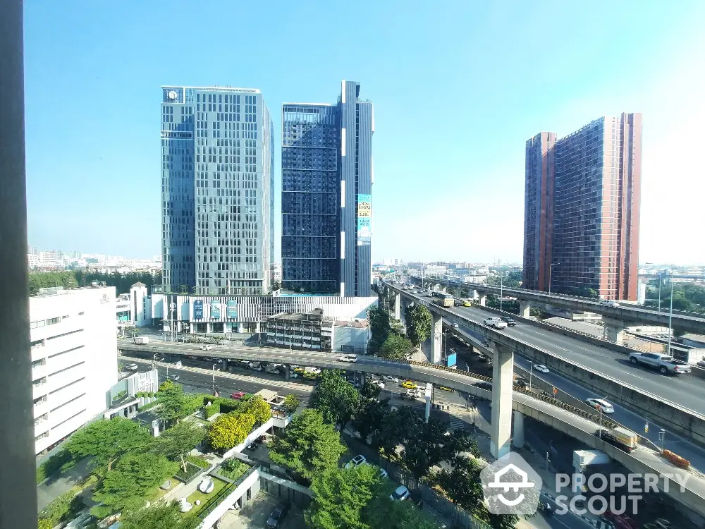 Stunning cityscape view with modern high-rise buildings and elevated highways, perfect for urban living.