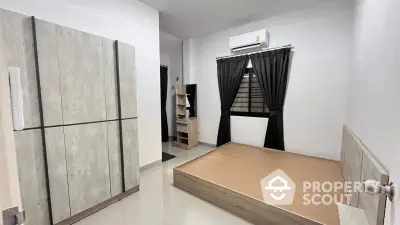 Spacious and modern bedroom with large bed platform, sleek built-in wardrobe, and air conditioning unit, perfect for urban living.