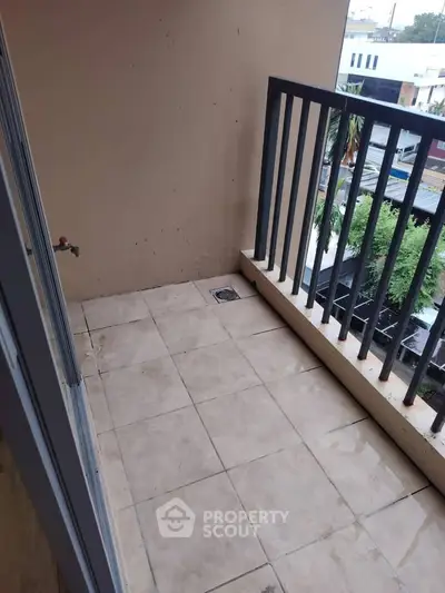 Charming balcony with tiled flooring and railing, perfect for enjoying city views.