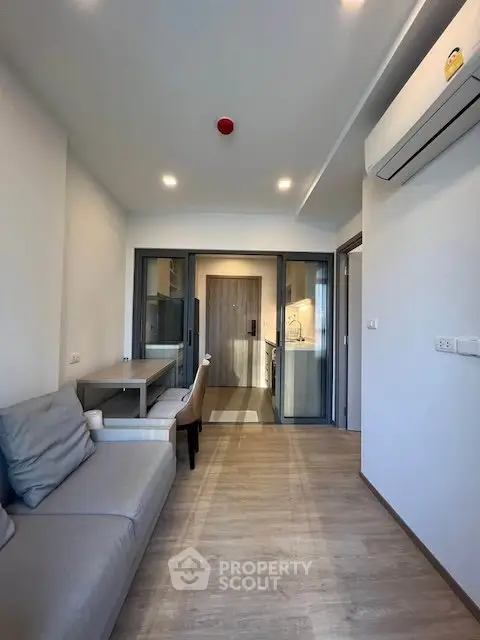 Modern living room with sleek design and open kitchen layout in a stylish apartment.