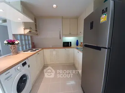 Modern kitchen with sleek appliances and washing machine in cozy layout