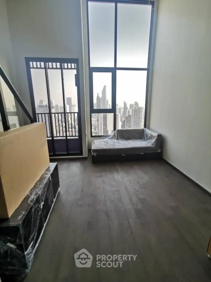 Modern high-rise apartment with floor-to-ceiling windows and stunning city view.