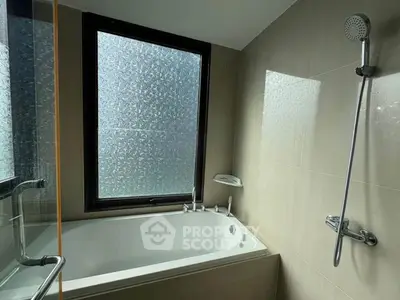 Modern bathroom with bathtub and frosted window for privacy