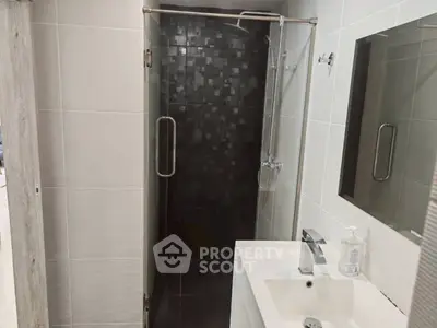 Modern bathroom with sleek shower and stylish sink in contemporary design.