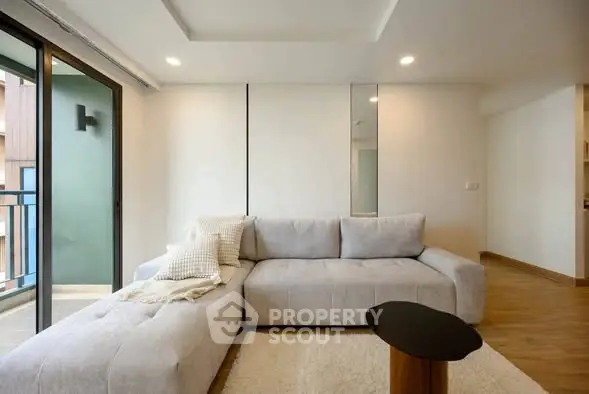 Modern living room with cozy sofa and balcony access in a stylish apartment.