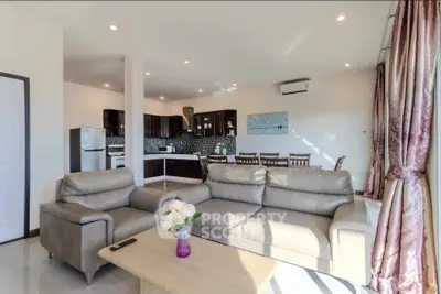 Spacious open-plan living room with modern kitchen and elegant decor