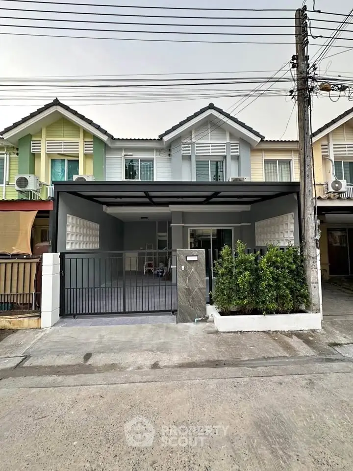 Charming townhouse with modern facade and gated driveway in a serene neighborhood.