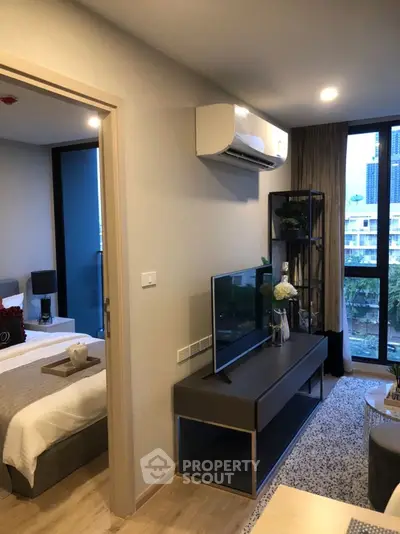 Modern living room with TV, air conditioning, and city view from window