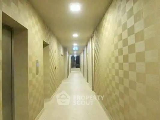 Modern apartment building corridor with stylish lighting and patterned walls.