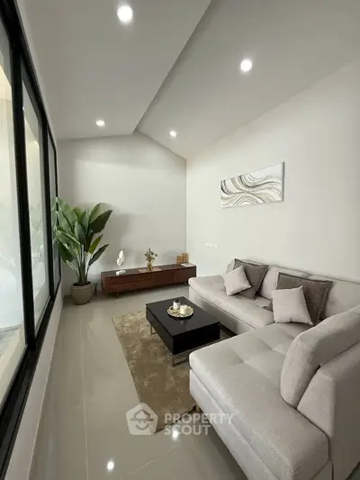 Modern living room with sleek furniture and large windows, perfect for relaxation and entertaining.