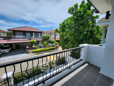 Charming balcony with scenic neighborhood view and lush greenery.