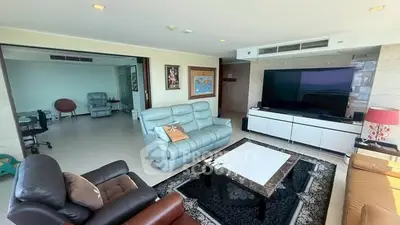 Spacious living room with modern furniture and large TV, perfect for relaxation and entertainment.