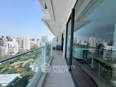 Stunning high-rise balcony with panoramic city views and modern glass railing.