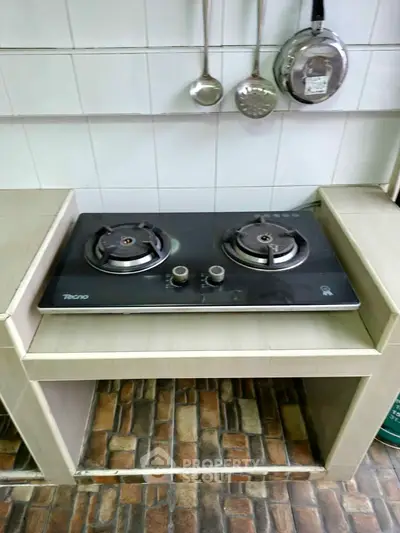 Modern kitchen with gas stove and tiled backsplash, perfect for culinary enthusiasts.