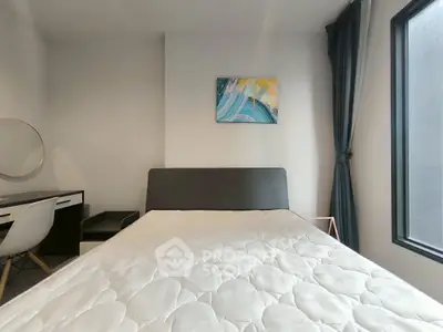 Modern bedroom with stylish decor and large window for natural light.