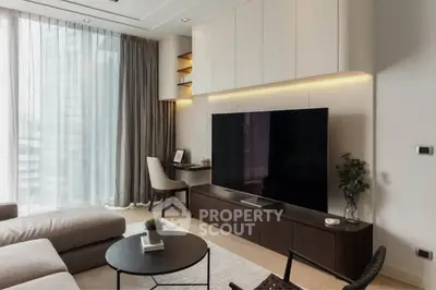 Modern living room with large TV, stylish furniture, and floor-to-ceiling windows.