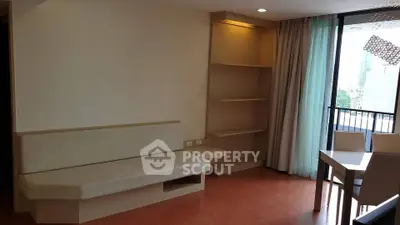Modern living room with built-in shelves and balcony view in urban apartment.