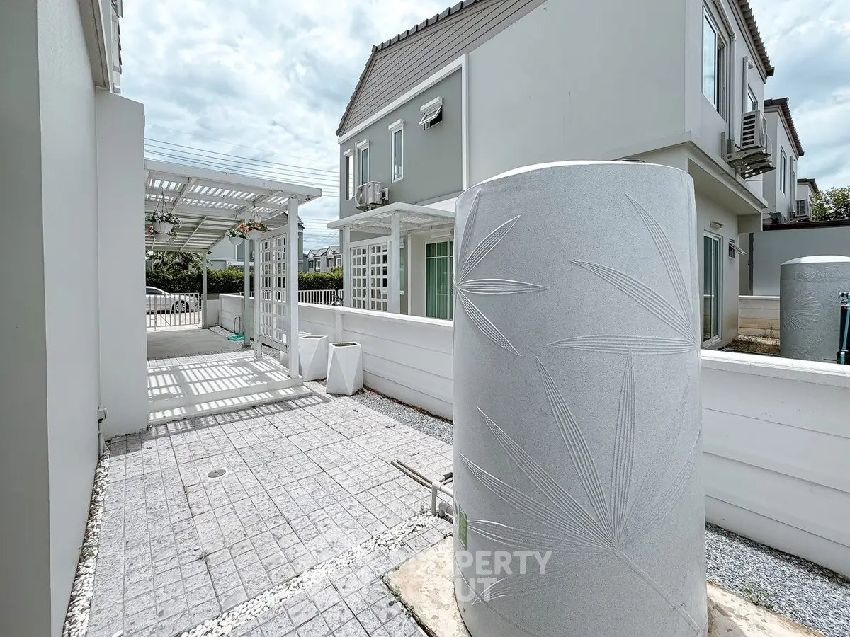 Modern residential exterior with stylish water tank and patio area