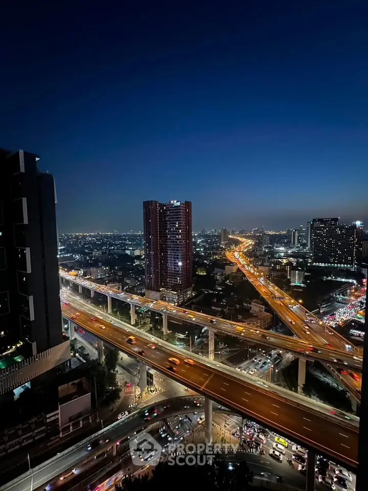 Stunning cityscape view from high-rise building at night with illuminated highways and skyline.
