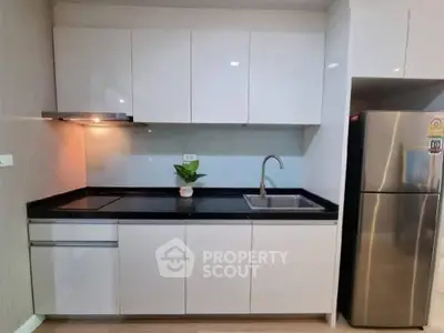 Modern kitchen with sleek cabinetry and stainless steel appliances in a stylish apartment.