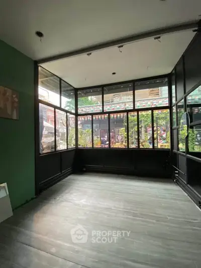 Spacious sunlit room with large windows and modern flooring