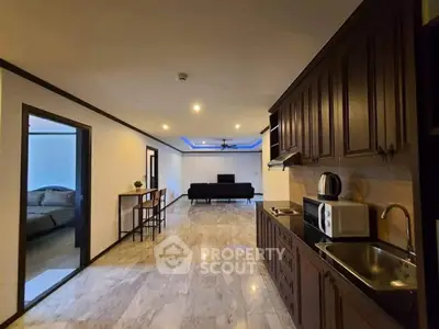 Spacious open-plan living room with modern kitchen and sleek marble flooring.
