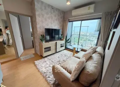 Modern living room with cozy sofa, TV, and balcony view in stylish apartment.