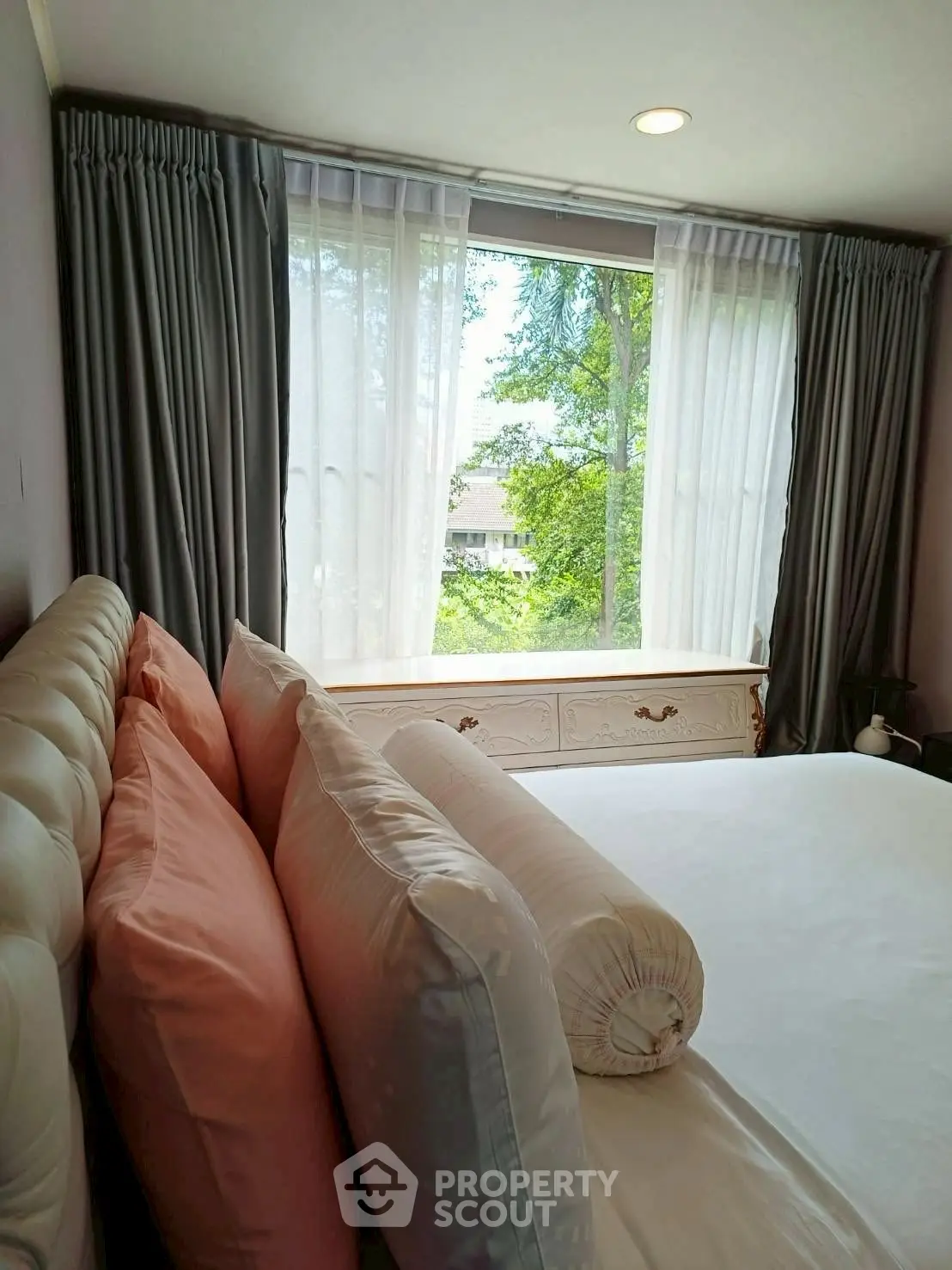 Cozy bedroom with large window and lush green view