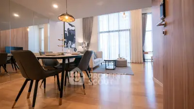 Modern open-plan living and dining area with stylish furniture and large windows.