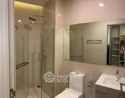 Modern bathroom with glass shower and sleek fixtures in a contemporary apartment.