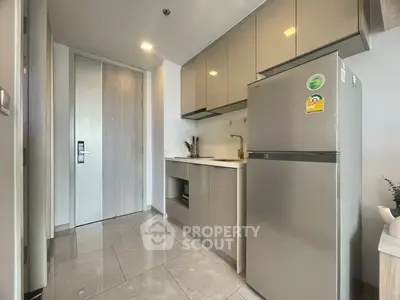 Modern kitchen with sleek cabinetry and stainless steel appliances in a stylish apartment.