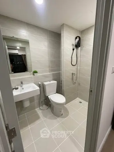 Modern bathroom with sleek tiles and shower in a contemporary apartment.
