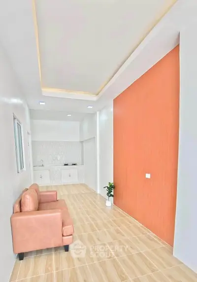 Modern living room with sleek design, featuring a cozy sofa and stylish kitchen area, perfect for urban living.
