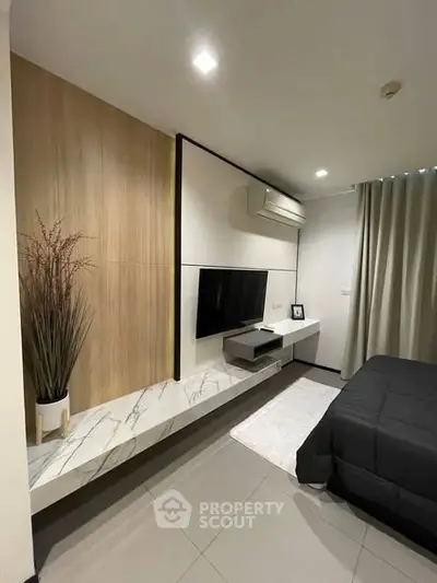 Modern bedroom with sleek TV setup and elegant decor