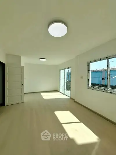 Spacious empty room with large windows and modern lighting