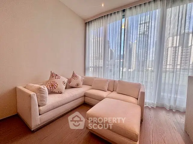 Elegant living room with modern sofa and city view through large windows.