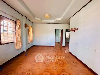 Spacious room with tiled flooring and natural light from large windows.