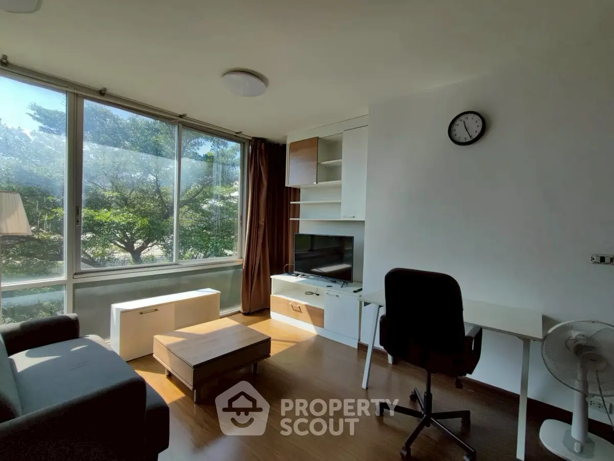 Bright living room with modern furniture and large windows offering a scenic view.