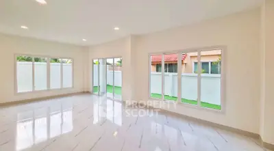 Spacious and bright living room with large windows and modern flooring.