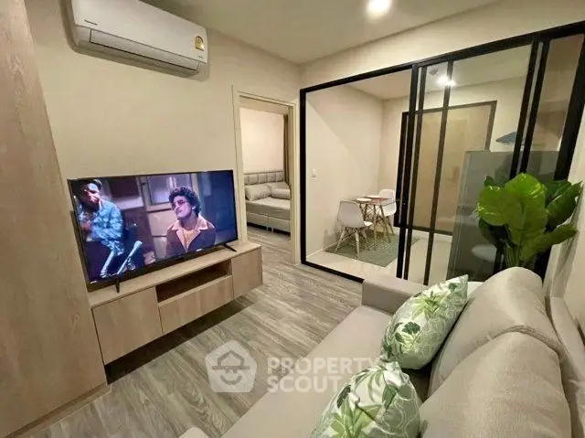 Modern living room with stylish decor and open layout, featuring a cozy seating area and sleek TV setup.