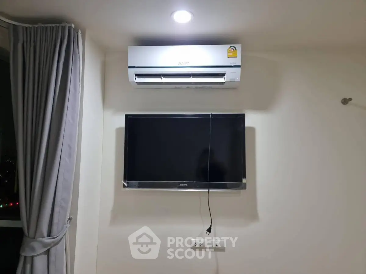 Modern living room with air conditioner and wall-mounted TV for comfort and entertainment.